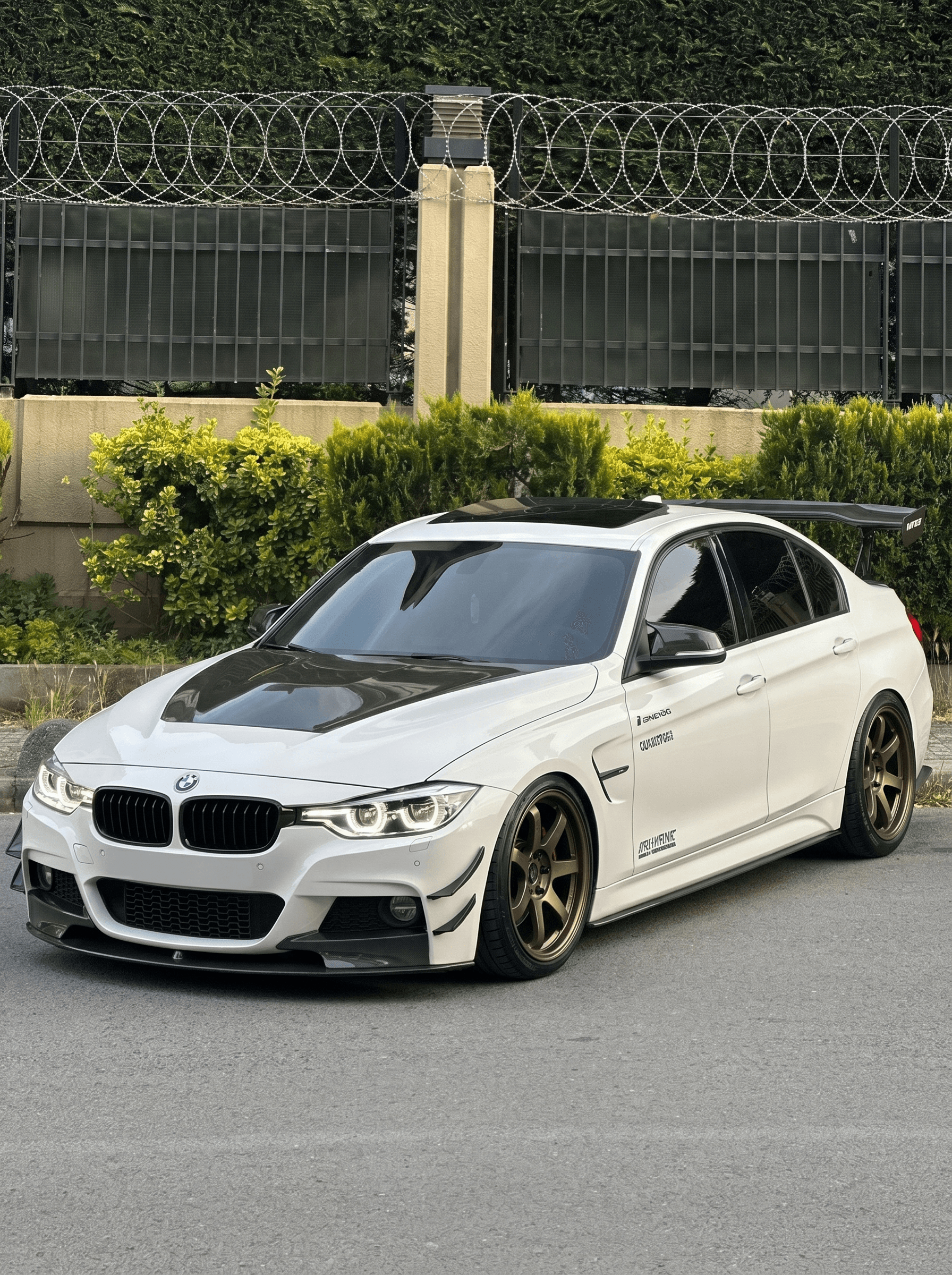 White BMW 3 Series with carbon hood and bronze wheels